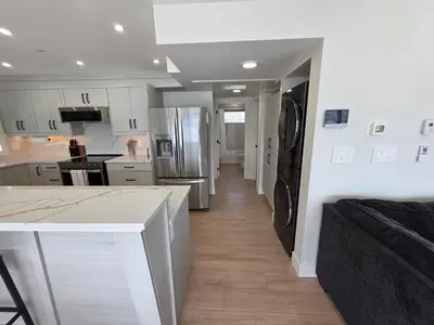 a kitchen with a refrigerator and a counter top at Premium Deluxe PeachView Suites 3BR in Peachland