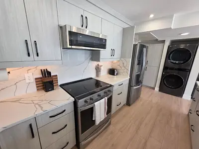 a kitchen with a stove and a refrigerator at Premium Deluxe PeachView Suites 3BR in Peachland