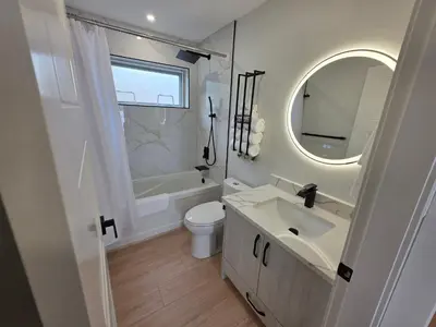 a bathroom with a sink and a toilet and a mirror at Premium Deluxe PeachView Suites 3BR in Peachland