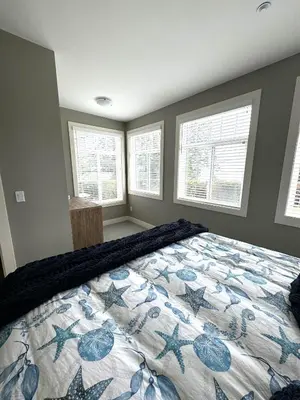 a bedroom with a bed with a quilt on it at White Rock Beach getaway in White Rock