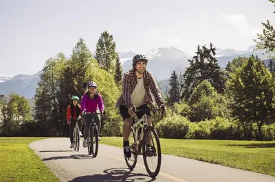 a couple of people riding bikes down a path at Bear Lodge, Whistler Village - Spectacular Location on Village Stroll, Designer Remodel in Whistler