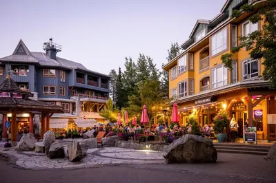 a group of people sitting around a fountain in front of a building at Bear Lodge, Whistler Village - Spectacular Location on Village Stroll, Designer Remodel in Whistler