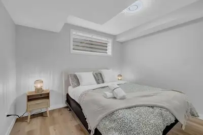 a white bedroom with a bed and a night stand at ModernSuite*NearAirport*2Queens*2Bedroom*FullKitchen in Edmonton