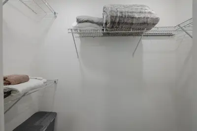 a white room with a shelf with towels on it at Townhome with Free Parking, Near Downtown in Calgary