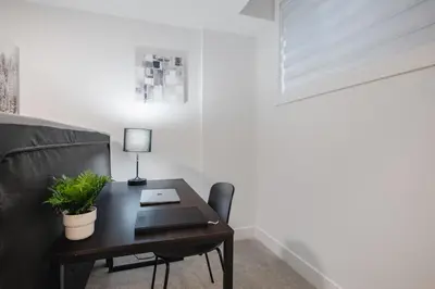 a desk with a plant on it next to a couch at Townhome with Free Parking, Near Downtown in Calgary