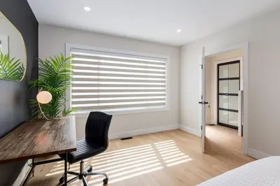 a bedroom with a desk and a window with a plant at Pet Friendly & Accessible, 4 Beds in Calgary