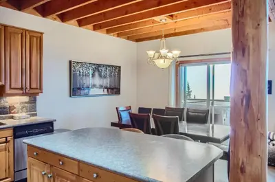 a kitchen and dining room with a table and chairs at Snowy Creek by Okanagan Premier in Big White