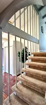 a staircase in a house with a potted plant at White House Tofino Downtown Villa in Tofino