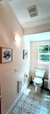 a bathroom with a white toilet and a window at White House Tofino Downtown Villa in Tofino