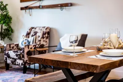 a wooden table with wine glasses and a chair at Tucker's Place in Revelstoke