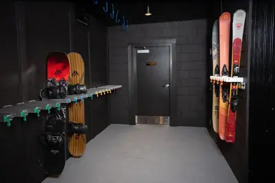 a room with a bunch of snowboards on a wall at Gravity Haus Revelstoke in Revelstoke