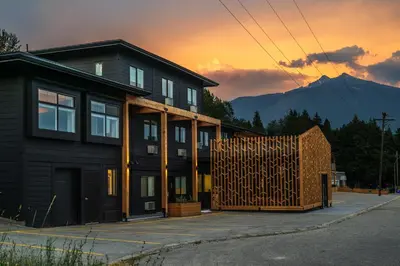 a house with a wooden fence in front of it at Gravity Haus Revelstoke in Revelstoke