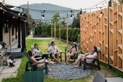 a group of people sitting in chairs on a patio at Gravity Haus Revelstoke in Revelstoke