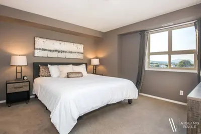 a bedroom with a large white bed and a window at Contemporary, Cozy, Pool, Hot Tub, Lake Front in Invermere