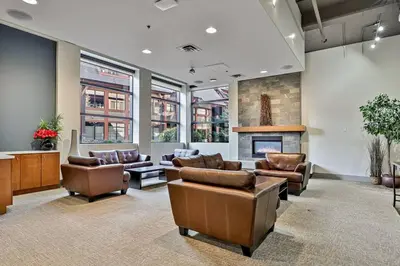 a lobby with leather furniture and a fireplace at Magnificent Mountain Penthouse - Hot Tub & Pool managed by Little Sister Getaways in Canmore