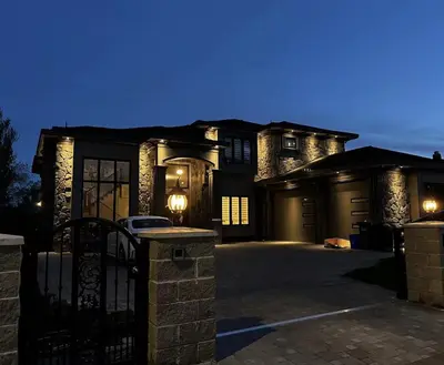 a large house with a driveway at night at Home In Vancouver in Richmond