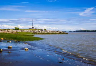 a body of water with a lighthouse in the distance at Home In Vancouver in Richmond