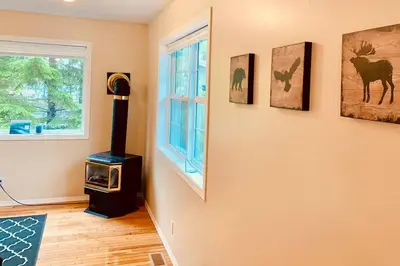 a living room with a stove and a window at Blue Cedar Suite in Tofino