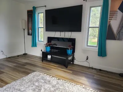 a living room with a flat screen tv on the wall at Farmhouse in Alberta in Duffield