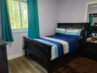 a bedroom with a bed with blue and white sheets at Farmhouse in Alberta in Duffield