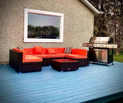 a patio with a couch and a grill and a barbecue at Farmhouse in Alberta in Duffield