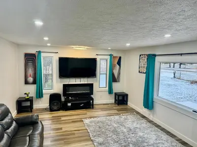 a living room with a couch and a flat screen tv at Farmhouse in Alberta in Duffield