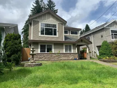 a house with a grass yard in front of it at 3 Bedrooms 1 Bath in SHARE HOUSE at Coquitlam Central Mall & skytrain in Port Coquitlam