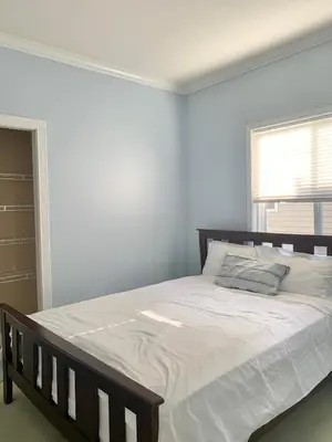 a bedroom with a large bed with white sheets at 3 Bedrooms 1 Bath in SHARE HOUSE at Coquitlam Central Mall & skytrain in Port Coquitlam