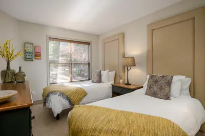 a hotel room with two beds and a window at 2BR in Blackcomb Greens, Wood Fireplace, Hot Tub Access, Mountain Views, Free Ski Shuttle, Parking in Whistler