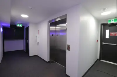 a hallway with two elevators in a building at Premium Deluxe suites 201 in Peachland