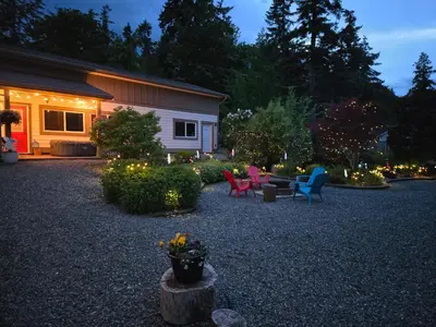 a yard with chairs and a table with lights at The White Rabbit Inn in Courtenay