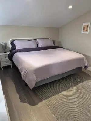 a bedroom with a large bed and a rug at The White Rabbit Inn in Courtenay