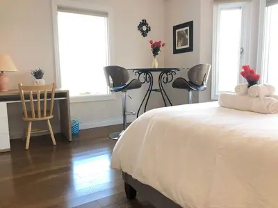 a bedroom with a bed and a table and chairs at heated pool, hot tub, 3 AC ensuites, lake view in West Kelowna