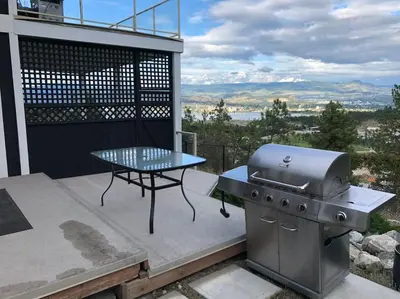 a grill and a picnic table on a patio at heated pool, hot tub, 3 AC ensuites, lake view in West Kelowna