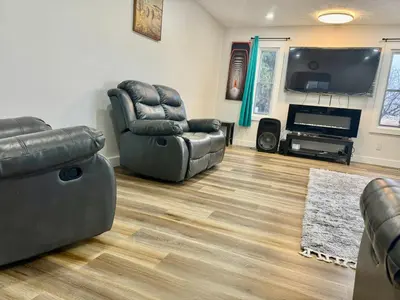 a living room with two chairs and a flat screen tv at DreamLand Farms, Edmonton in Duffield