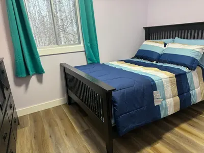 a bedroom with a bed with blue sheets and a window at DreamLand Farms, Edmonton in Duffield
