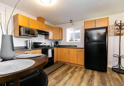 a kitchen with a black refrigerator and wooden cabinets at Super wow view! in Victoria