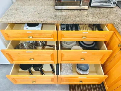 a kitchen counter with wooden drawers with dishes at 2BR 1BA Garden View Guest Suite - King-size Bed - Free Parking in Vancouver