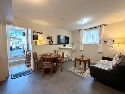 a living room with a table and a couch at 2BR 1BA Garden View Guest Suite - King-size Bed - Free Parking in Vancouver