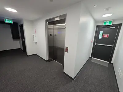a hallway of an office building with a elevator at PeachView Deluxe Suites 301 in Peachland