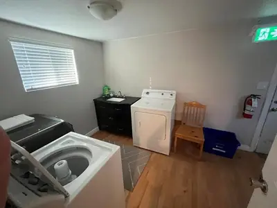 a laundry room with a washing machine and a washer at King and Queen rooms -J&J Chilliwack in Chilliwack