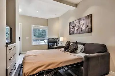 a bedroom with a bed and a couch at Mountain Surrounded Lodge in Harvie Height in Canmore