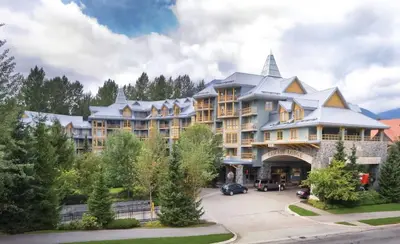 a large apartment building with a parking lot at KING Bed - Premium STUDIO Suite - Ski Valet - Village in Whistler