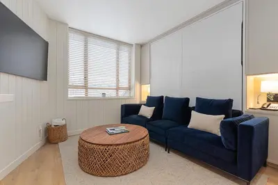 a living room with a blue couch and a table at KING Bed - Premium STUDIO Suite - Ski Valet - Village in Whistler