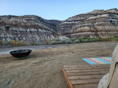 a campsite with a bucket and mountains in the background at D6 Sahara Sunset- King Suite Very Private in Drumheller