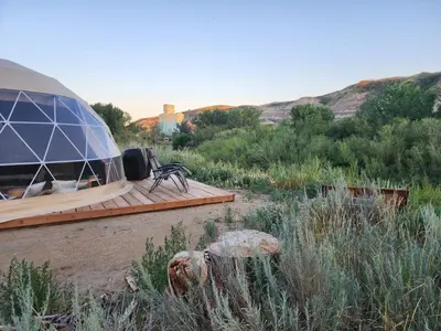 a dome building with a wooden deck in a field at D6 Sahara Sunset- King Suite Very Private in Drumheller