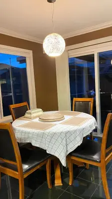a dining room table with chairs and a chandelier at Warm home in Richmond