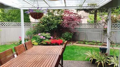 a wooden bench in a garden with flowers at Warm home in Richmond