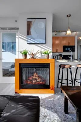 a living room with a fireplace in a kitchen at Stylish 2BD Condo in Downtown with Marina View in Vancouver