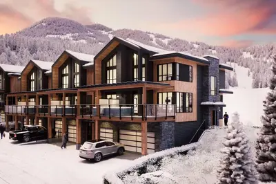 a house in the snow with a car parked in front at Nordix Townhomes by StayIn in Panorama
